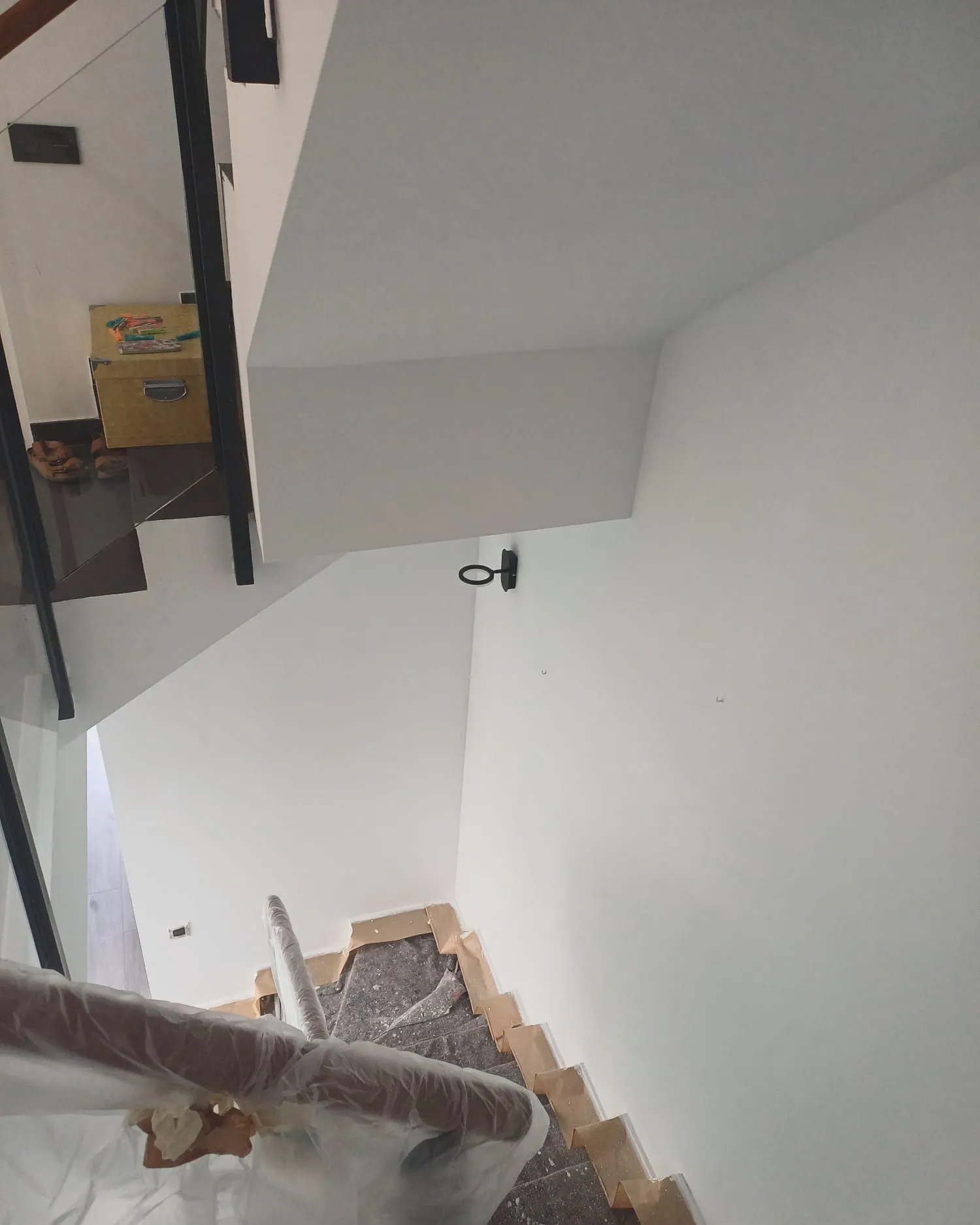 Hueco de escalera interior con paredes y techo recién pintados en blanco
